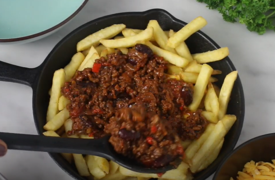 Layer french fries and chilli in a pan